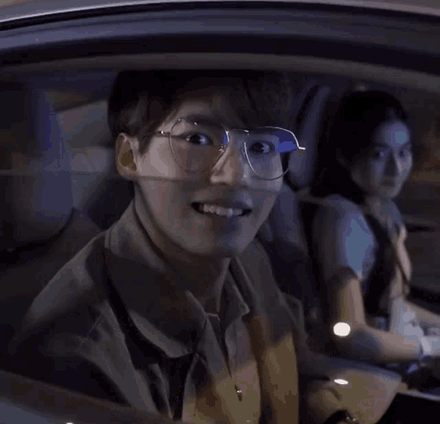 a man wearing glasses is looking out the window of a car