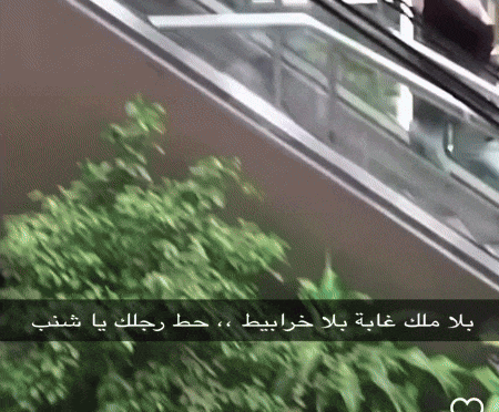 a picture of an escalator with arabic writing on the bottom