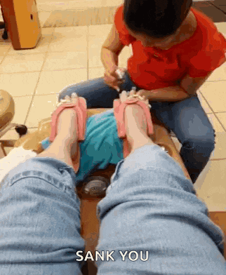 a woman is getting her feet painted at a nail salon and the caption says sank you .
