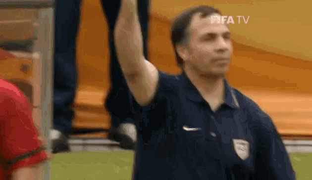 a man in a nike shirt is raising his hand in the air