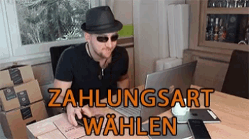 a man wearing a hat and sunglasses is sitting at a table with a laptop and the words zahlungsart wahlen