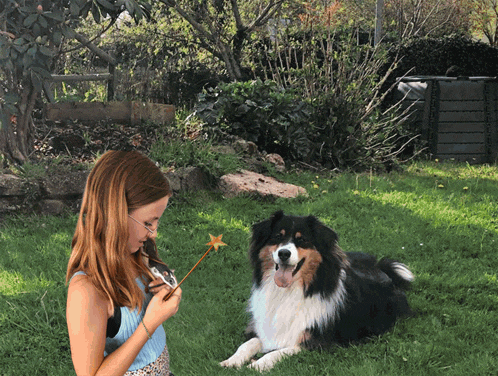 a girl is holding a magic wand in front of a dog
