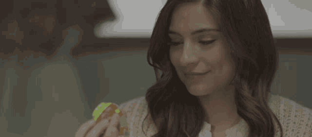 a woman is smiling while holding a rubik 's cube in her hands