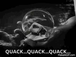 a black and white photo of a person holding a snow globe with a duck skull inside of it .