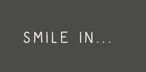 a sign that says good keep smiling on a gray background