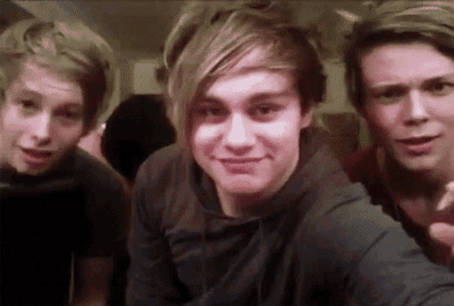 three young men are posing for a picture together and one of them is making a funny face
