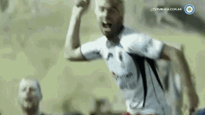 a man in a white shirt is running with his fist in the air .