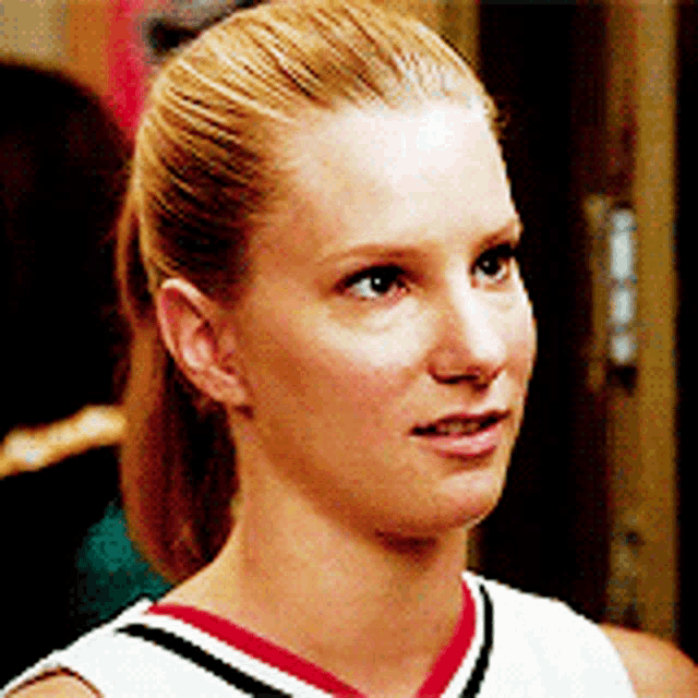 a close up of a woman 's face wearing a cheerleader uniform