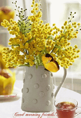 a bouquet of yellow flowers in a white vase with the words good morning friends written on the bottom