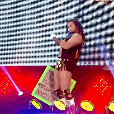 a wrestler is standing on a green sign that says `` you can 't kill myself '' .