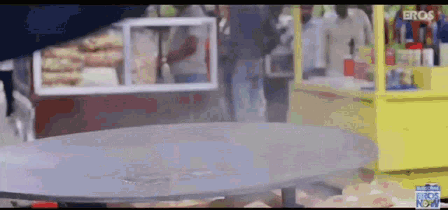 a blurred image of a food stand with the word eros on the bottom right