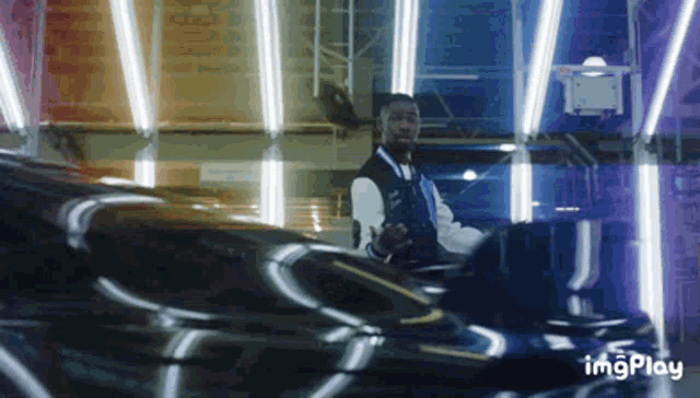 a gif of a man driving a car with the words imgplay in the lower right corner