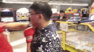 a man wearing red boxing gloves is being punched in the face