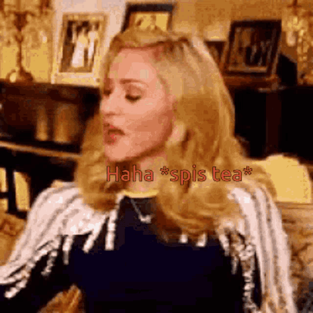 a woman with blonde hair is sitting in front of a table with the words haha spis tea written on it