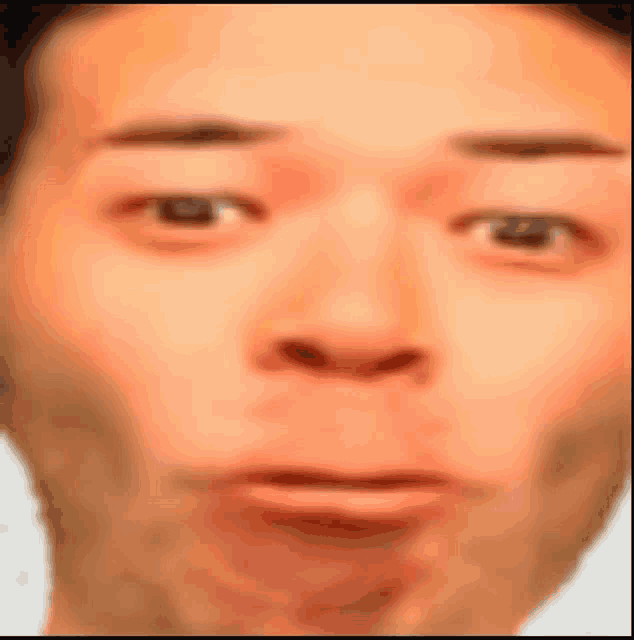 a close up of a man 's face with a surprised look on his face