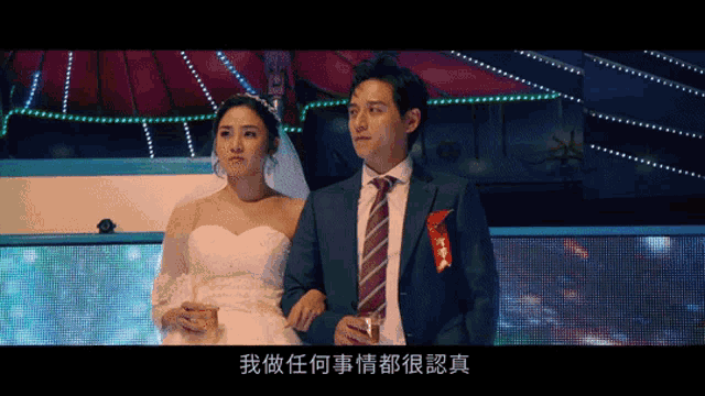 a man in a suit and tie stands next to a woman in a dress