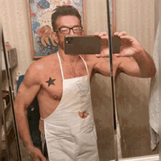 a shirtless man in an apron is taking a picture of himself in a mirror