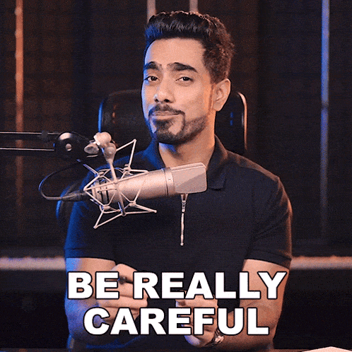 a man in front of a microphone with the words be really careful above him