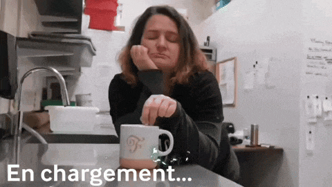 a woman sits at a counter with a cup of coffee and the words en chargement