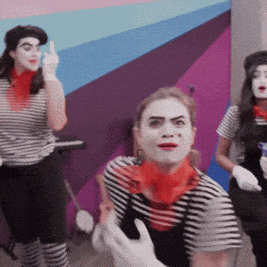 a woman in a striped shirt with a red scarf around her neck is making a funny face