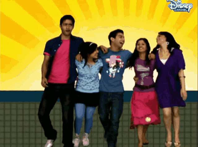 a group of people standing next to each other in front of a disney channel banner