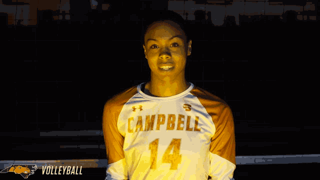 a person wearing a campbell 14 jersey stands in front of a volleyball net