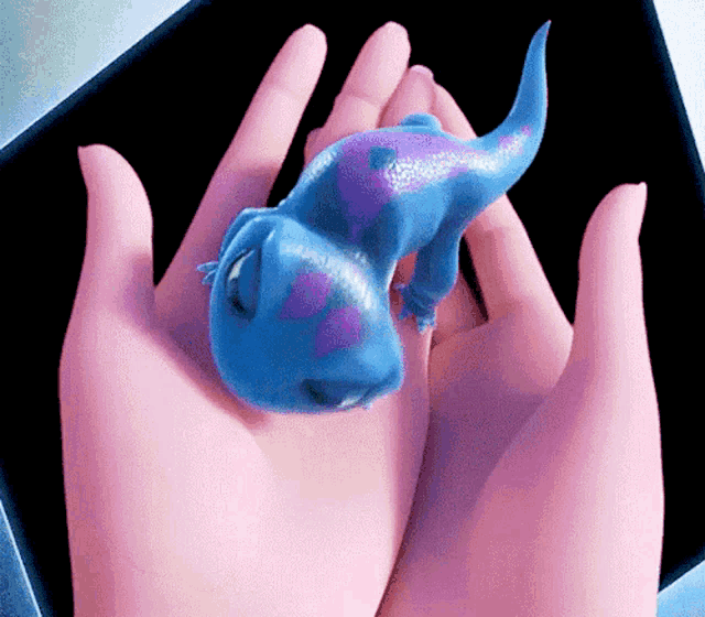 a person is holding a blue lizard in their hand