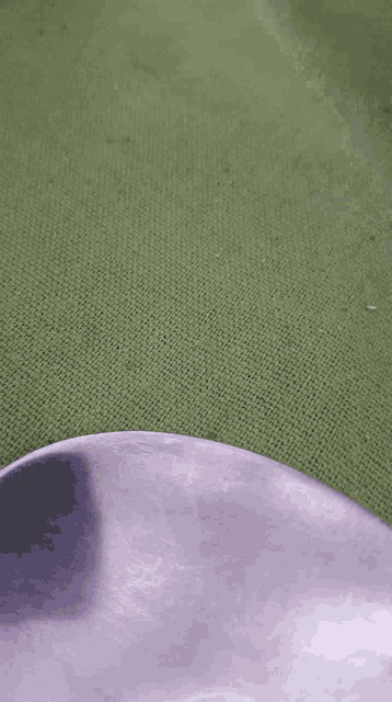 a close up of a silver spoon on a green cloth