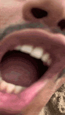 a close up of a person 's mouth with their tongue hanging out
