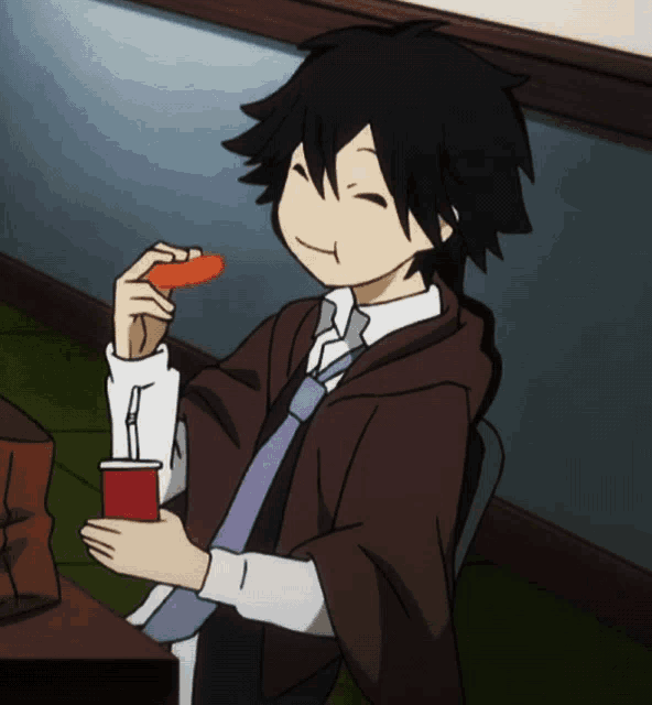 a boy in a suit and tie is eating a carrot