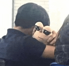 a man is holding a stuffed animal with sunglasses on its head .