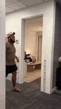 a man wearing a hat is walking through a hallway
