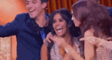 a group of people are standing next to each other and laughing together .