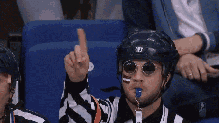 a hockey referee wearing sunglasses and a helmet with the letter t on it