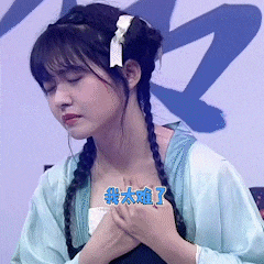 a woman with braids and a flower in her hair is wearing a blue shirt with chinese writing on it .