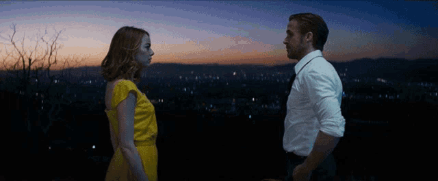 a man and a woman are looking at each other in the dark
