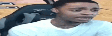 a man is sitting in a chair with his mouth open and making a funny face .