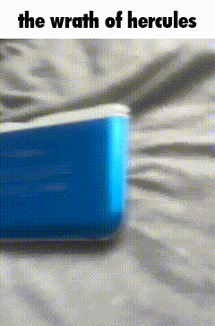 a blue cooler is laying on a bed with the words `` the wrath of hercules '' written on it .