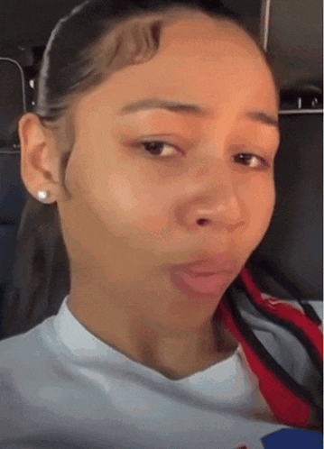 a woman wearing a white shirt and a red scarf is making a face
