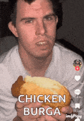 a man is eating a chicken burga sandwich .