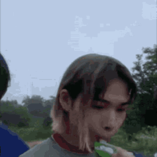 a close up of a person drinking a drink from a bottle .