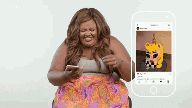 a woman looks at a picture of a unicorn cake on her phone