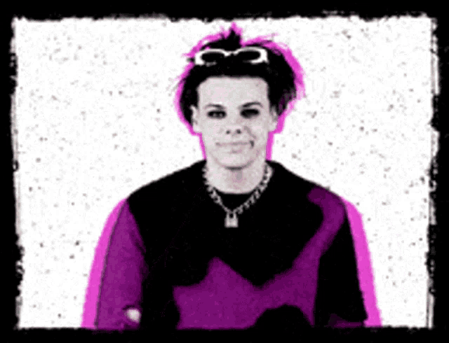 a man wearing a purple sweater and a chain necklace