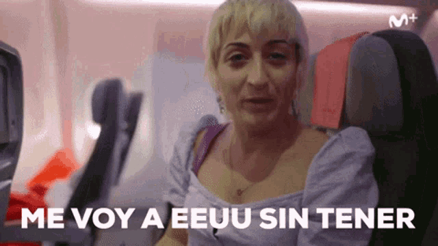 a woman sitting on an airplane with the words me voy a eeuu sin tener behind her