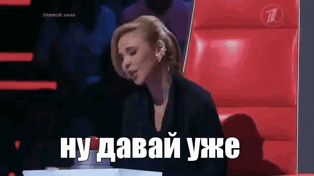 a woman is sitting in a red chair with a sign that says ну давай уже .