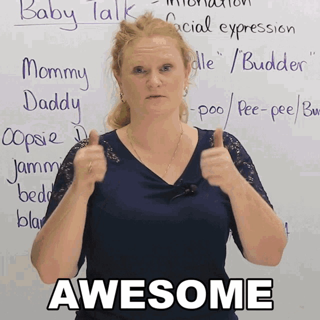 a woman is giving a thumbs up in front of a white board that says baby talk