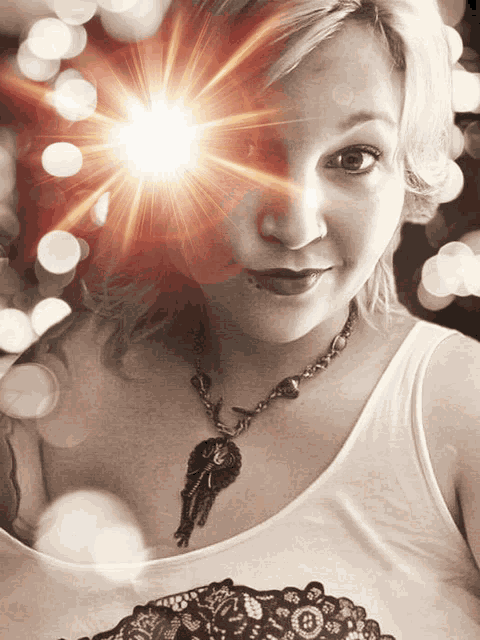 a woman wearing a white tank top and a necklace with a key pendant