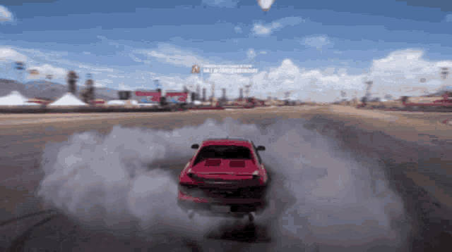 a red car is driving down a dirt road with smoke coming out of the back