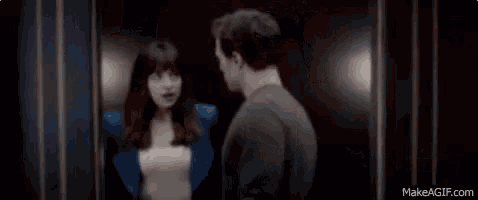 a man and a woman kissing in a dark room .