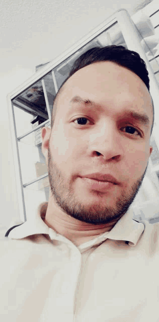 a man with a beard is taking a selfie